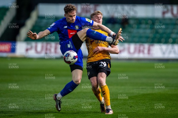 250423 - Newport County v Harrogate Town - Sky Bet League 2 - Toby Sims of Harrogate Town attempts to clear under pressure from Will Evans of Newport County