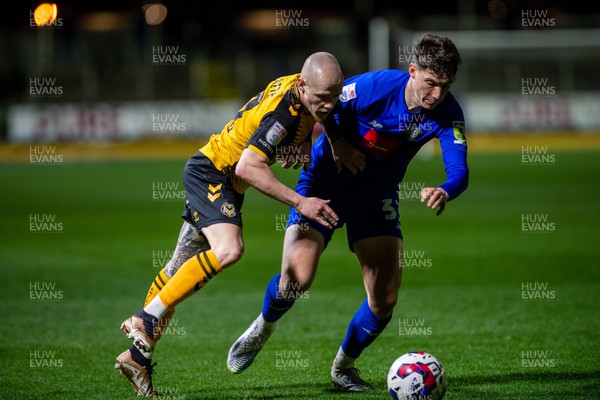 250423 - Newport County v Harrogate Town - Sky Bet League 2 - James Waite of Newport County is tackled by Matty Foulds of Harrogate Town