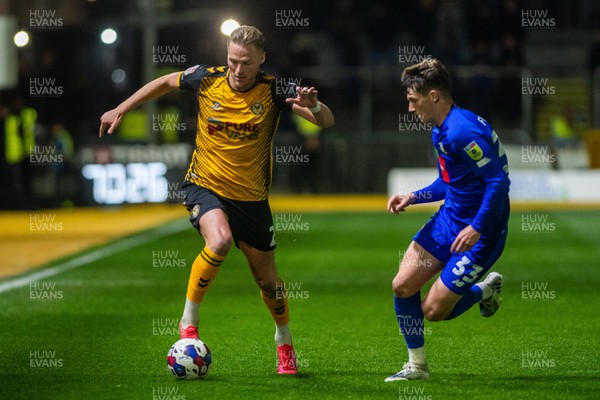 250423 - Newport County v Harrogate Town - Sky Bet League 2 - Cameron Norman of Newport County holds off Matty Foulds of Harrogate Town