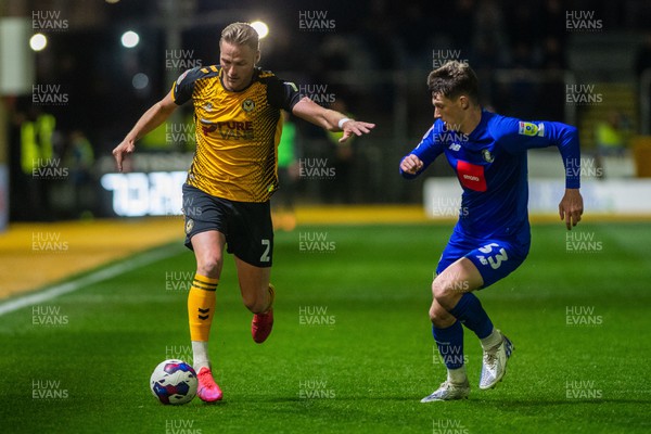 250423 - Newport County v Harrogate Town - Sky Bet League 2 - Cameron Norman of Newport County holds off Matty Foulds of Harrogate Town