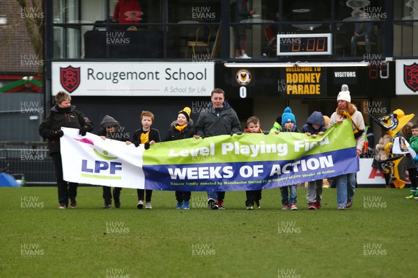 170318 - Newport County v Luton Town - Sky Bet League 2 - Children the Thrive Charity lead the teams out with the banner to promote The Disabled Supporters Association (DSA) celebrating Level Playing Fields (LPF) 2018 Weeks of Action campaign