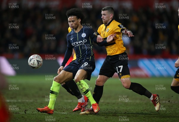 160219 - Newport County v Manchester City - FA Cup 5th Round - Leroy Sane of Manchester City is challenged by Scot Bennett of Newport County