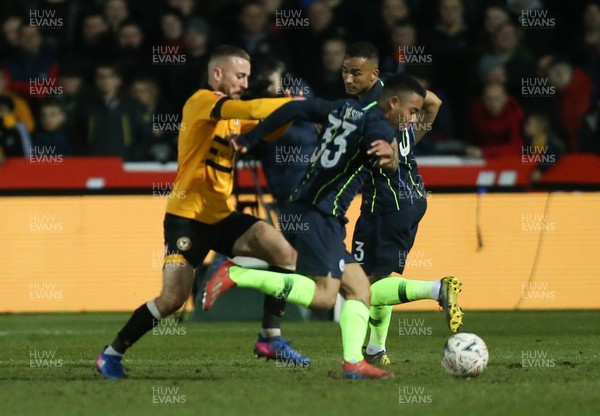 160219 - Newport County v Manchester City, FA Cup Fifth Round - Dan Butler of Newport County takes on Gabriel Jesus of Manchester City