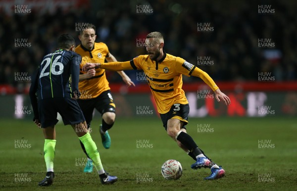 160219 - Newport County v Manchester City, FA Cup Fifth Round - Dan Butler of Newport County takes on Riyad Mahrez of Manchester City