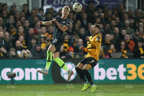 160219 - Newport County v Manchester City, FA Cup Fifth Round - Oleksandr Zinchenko of Manchester City heads the ball over Robbie Willmott of Newport County