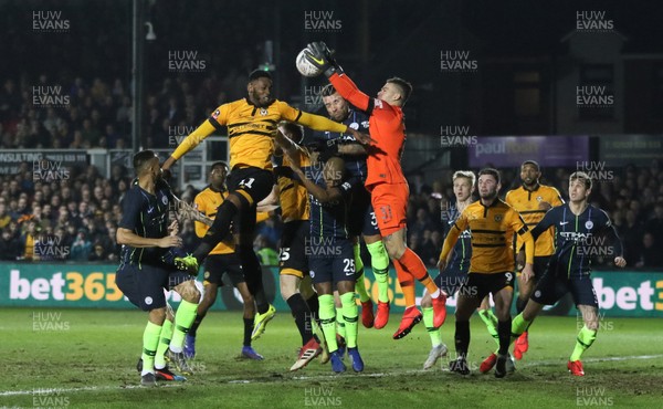 160219 - Newport County v Manchester City, FA Cup Fifth Round - Jamille Matt of Newport County competes for the ball with Manchester City goalkeeper Ederson