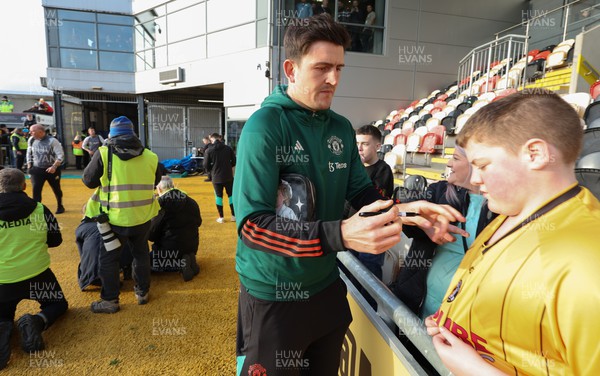 280124 - Newport County v Manchester United, FA Cup Fourth Round - Manchester United’s  Harry Maguire signs a shirt for a Newport County fan as he arrives at Rodney Parade ahead of the match