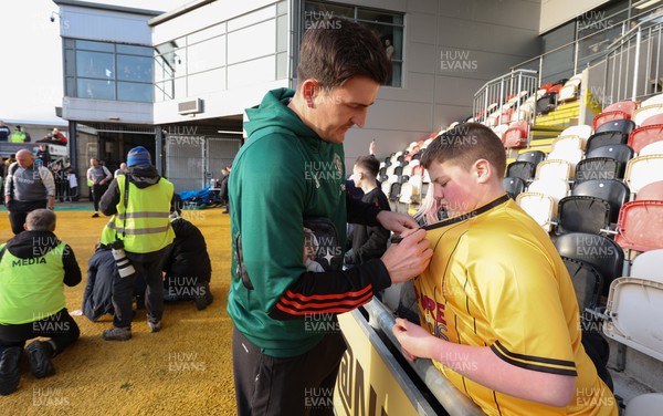 280124 - Newport County v Manchester United, FA Cup Fourth Round - Manchester United’s  Harry Maguire signs a shirt for a Newport County fan as he arrives at Rodney Parade ahead of the match