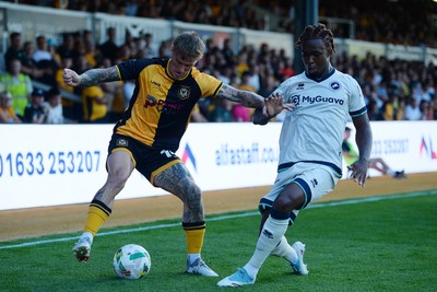 120825 - Newport County v Millwall - Carabao Cup Round 1 - Kai Whitmore of Newport County is challenged by Zak Sturge of Millwall