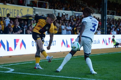 120825 - Newport County v Millwall - Carabao Cup Round 1 - Kai Whitmore of Newport County is challenged by Zak Sturge of Millwall