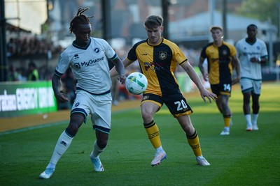 120825 - Newport County v Millwall - Carabao Cup Round 1 - Ben Lloyd of Newport County is challenged by Zak Sturge of Millwall