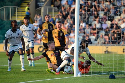120825 - Newport County v Millwall - Carabao Cup Round 1 - Cameron Evans of Newport County scrambles to try and put the ball over the line