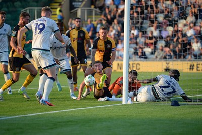 120825 - Newport County v Millwall - Carabao Cup Round 1 - Cameron Evans of Newport County scrambles to try and put the ball over the line