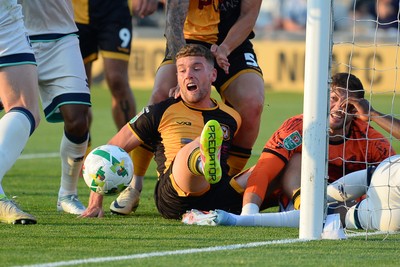 120825 - Newport County v Millwall - Carabao Cup Round 1 - Cameron Evans of Newport County scrambles to try and put the ball over the line