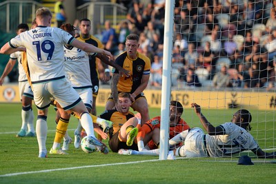 120825 - Newport County v Millwall - Carabao Cup Round 1 - Cameron Evans of Newport County scrambles to try and put the ball over the line