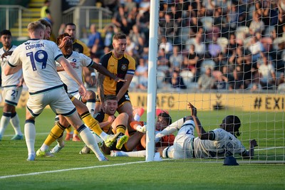 120825 - Newport County v Millwall - Carabao Cup Round 1 - Cameron Evans of Newport County scrambles to try and put the ball over the line