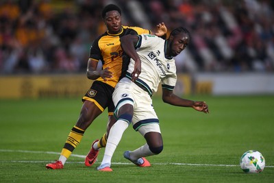 120825 - Newport County v Millwall - Carabao Cup Round 1 - Bobby Kamwa of Newport County is challenged by Macaulay Langstaff of Millwall