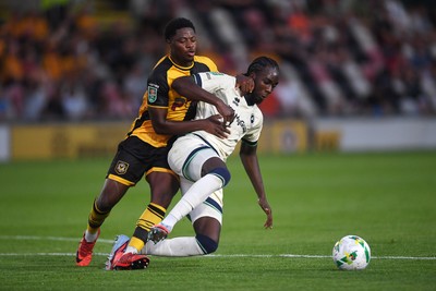 120825 - Newport County v Millwall - Carabao Cup Round 1 - Bobby Kamwa of Newport County is challenged by Macaulay Langstaff of Millwall