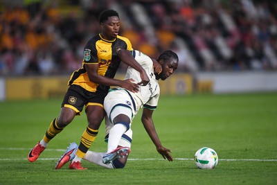 120825 - Newport County v Millwall - Carabao Cup Round 1 - Bobby Kamwa of Newport County is challenged by Macaulay Langstaff of Millwall