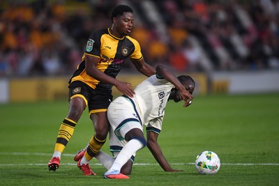 120825 - Newport County v Millwall - Carabao Cup Round 1 - Bobby Kamwa of Newport County is challenged by Macaulay Langstaff of Millwall
