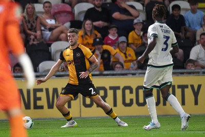 120825 - Newport County v Millwall - Carabao Cup Round 1 - Cameron Evans of Newport County is challenged by Zak Sturge of Millwall