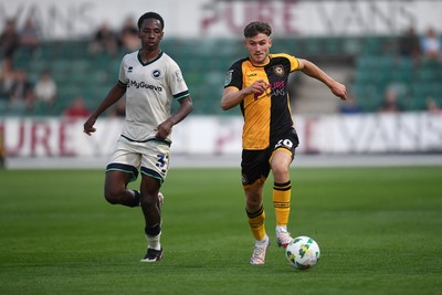 120825 - Newport County v Millwall - Carabao Cup Round 1 - Ben Lloyd of Newport County is challenged by Ra'ees Bangura-Williams of Millwall
