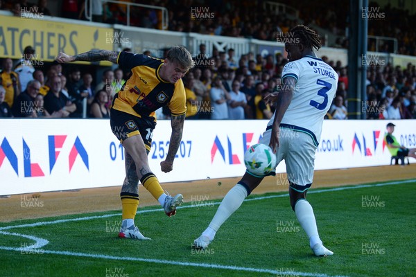120825 - Newport County v Millwall - Carabao Cup Round 1 - Kai Whitmore of Newport County is challenged by Zak Sturge of Millwall