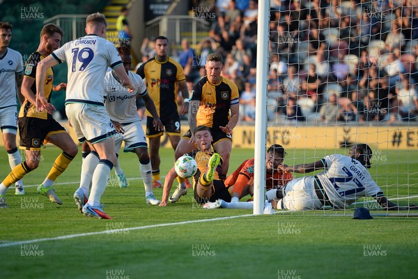 120825 - Newport County v Millwall - Carabao Cup Round 1 - Cameron Evans of Newport County scrambles to try and put the ball over the line