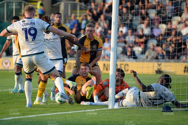 120825 - Newport County v Millwall - Carabao Cup Round 1 - Cameron Evans of Newport County scrambles to try and put the ball over the line