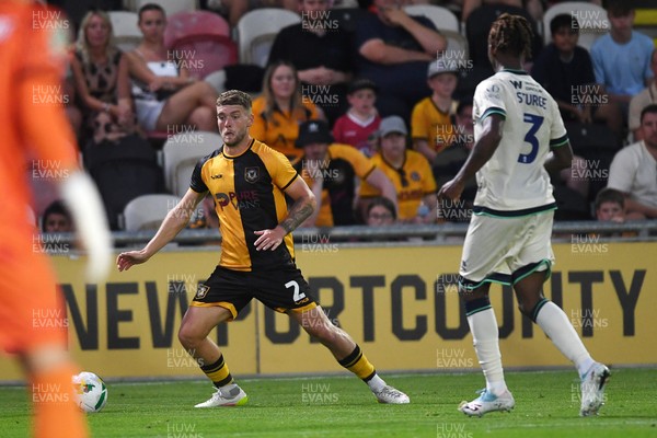120825 - Newport County v Millwall - Carabao Cup Round 1 - Cameron Evans of Newport County is challenged by Zak Sturge of Millwall