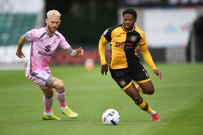 230825 - Newport County v Milton Keynes Dons - Sky Bet League 2 - Bobby Kamwa of Newport County is challenged by Gethin Jones of MK Dons