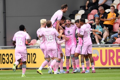 230825 - Newport County v Milton Keynes Dons - Sky Bet League 2 - Callum Paterson of MK Dons celebrates scoring a goal with team mates