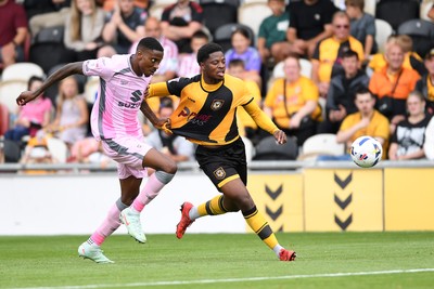 230825 - Newport County v Milton Keynes Dons - Sky Bet League 2 - Bobby Kamwa of Newport County is challenged by Marvin Ekpiteta of MK Dons