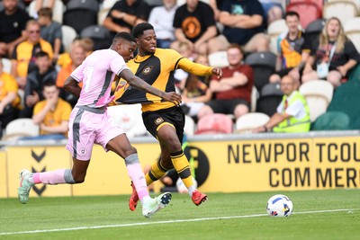 230825 - Newport County v Milton Keynes Dons - Sky Bet League 2 - Bobby Kamwa of Newport County is challenged by Marvin Ekpiteta of MK Dons
