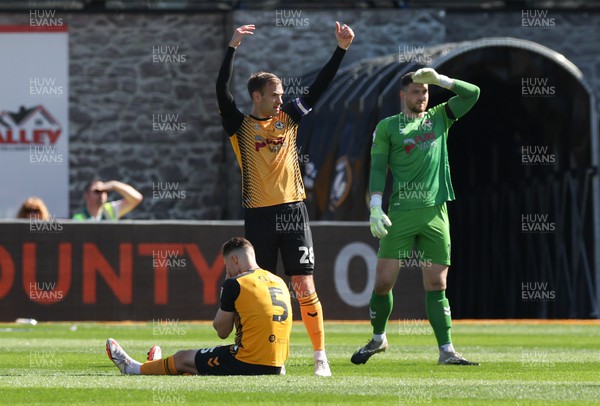 070423 - Newport County v Northampton Town, EFL Sky Bet League 2 - Mickey Demetriou of Newport County indicates treatment for James Clarke of Newport County after an injury