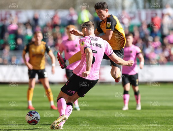 070423 - Newport County v Northampton Town, EFL Sky Bet League 2 - Calum Kavanagh of Newport County closes in on Jon Guthrie of Northampton Town as he clears the ball