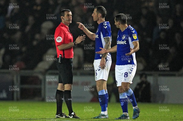 231119 - Newport County v Oldham Athletic, Sky Bet League 2 - Referee Craig Hicks with Chris McCann of Oldham Athletic (centre)