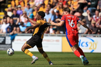 250426 - Newport County v Oldham Athletic - Sky Bet League 2 - Bobby Kamwa of Newport County battles for the ball with Will Sutton of Oldham Athletic
