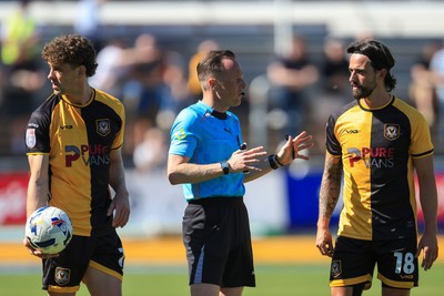 250426 - Newport County v Oldham Athletic - Sky Bet League 2 - Liam Shephard of Newport County, referee David Rock and Harrison Biggins of Newport County