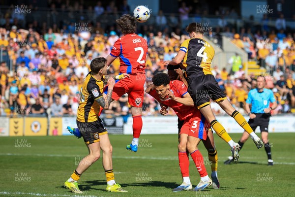 250426 - Newport County v Oldham Athletic - Sky Bet League 2 - Matthew Baker of Newport County challenges for the aerial ball with Reagan Ogle of Oldham Athletic
