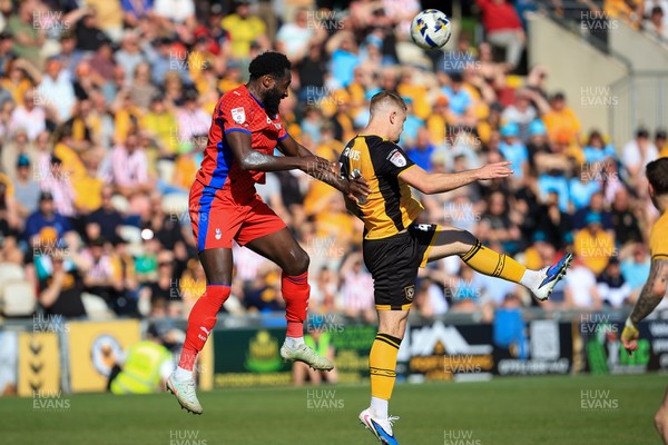 250426 - Newport County v Oldham Athletic - Sky Bet League 2 - Cole Jarvis of Newport County challenges for the aerial ball with Dynel Simeu of Oldham Athletic