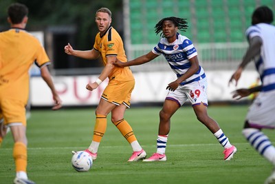 280726 - Newport County v Reading - Preseason Friendly - Cameron Norman of Newport County is challenged by Emmanuel Osho of Reading