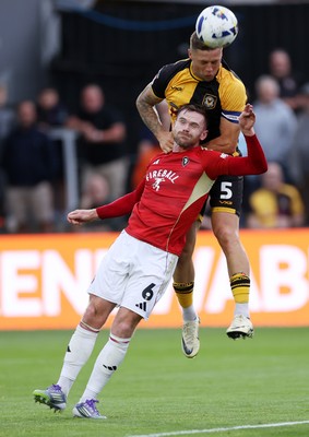 190825 - Newport County v Salford City - SkyBet League Two - Oliver Turton of Salford City and James Clarke of Newport County go up for the ball