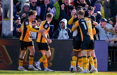 280326 - Newport County v Shrewsbury Town - Sky Bet League 2 - Players of Newport County celebrate after Bobby Kamwa (obscured) scores his team’s first goal