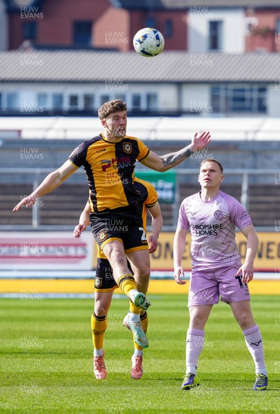 280326 - Newport County v Shrewsbury Town - Sky Bet League 2 - Cameron Evans of Newport County contends for the aerial ball with Anthony Scully of Shrewsbury Town