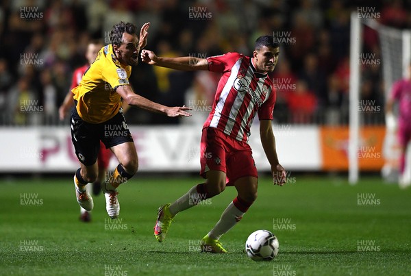 250821 - Newport County v Southampton - Carabao Cup - Mohamed Elyounoussi of Southampton is tackled by Edward Upson of Newport County