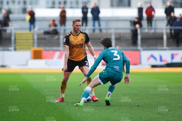 250223 - Newport County v Sutton United - Sky Bet League 2 - Cameron Norman of Newport County is closed down by Sam Hart of Sutton United 
