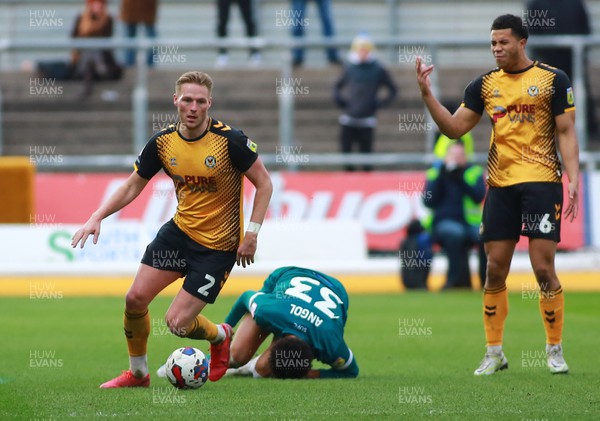 250223 - Newport County v Sutton United - Sky Bet League 2 - Cameron Norman of Newport County beats Lee Angol of Sutton United 