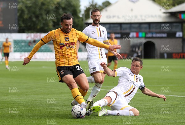 260823 - Newport County v Sutton United - SkyBet League Two - Aaron Wildig of Newport County is tackled by Harry Beautyman of Sutton United 
