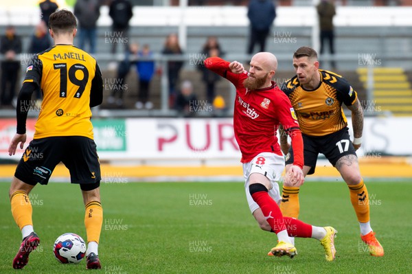 040223 - Newport County v Swindon Town - Sky Bet League 2 - Jonny Williams of Swindon Town against Charlie McNeill (19) and Scot Bennett of Newport County 